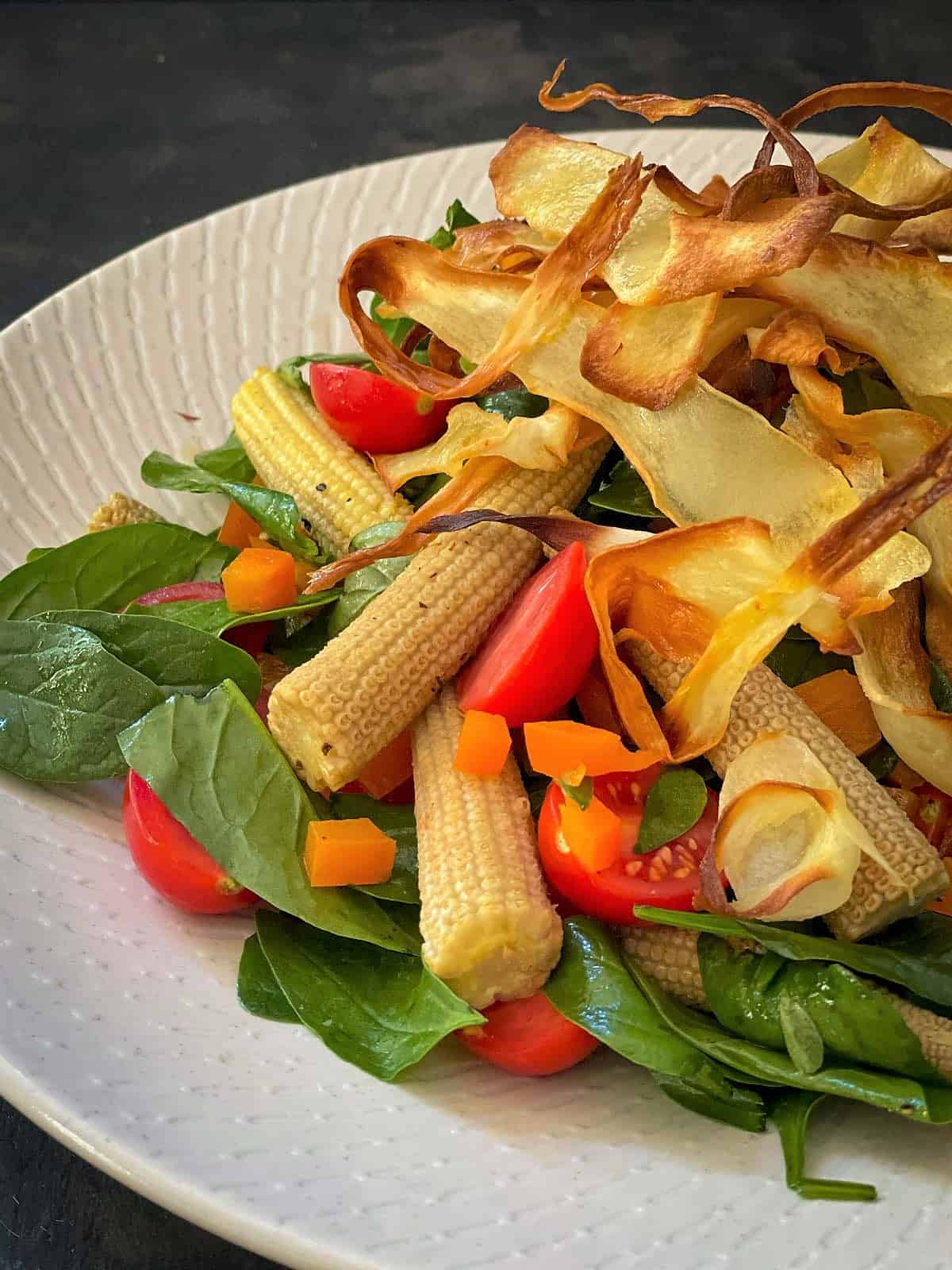 Baby Corn Salad with Crisp Parsnip Ribbons on a white plate