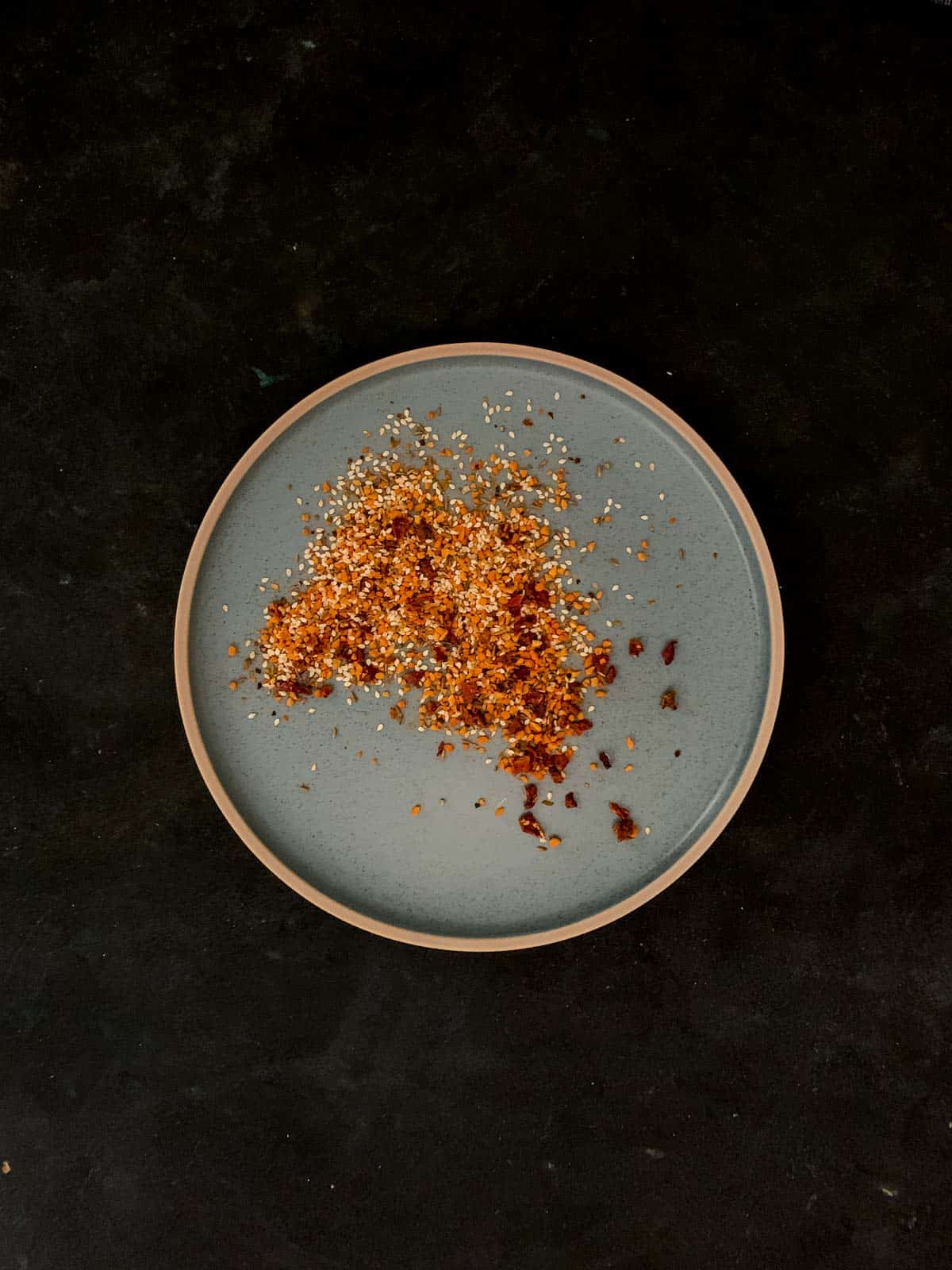 Dukkah spice mix on a round green plate