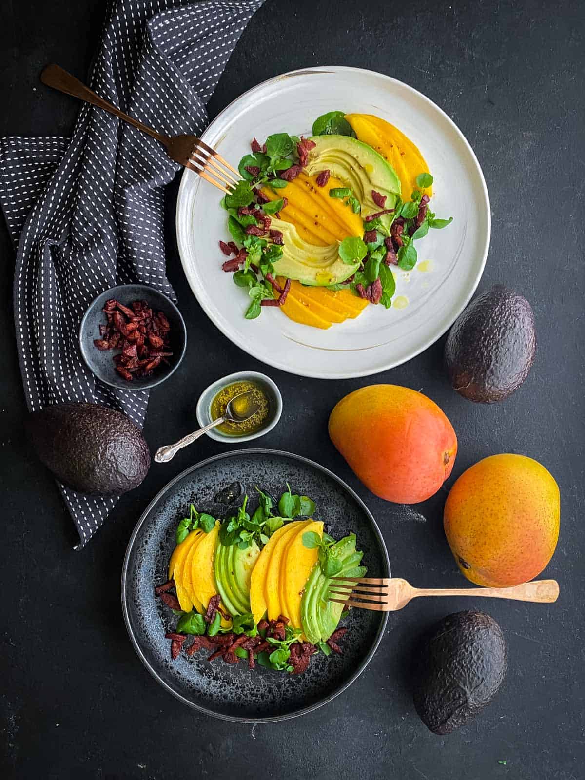 2 serves of Mango Avocado Salad with Crispy Chorizo surrounded by whole mangoes, avocadoes and bowl of chopped chorizo