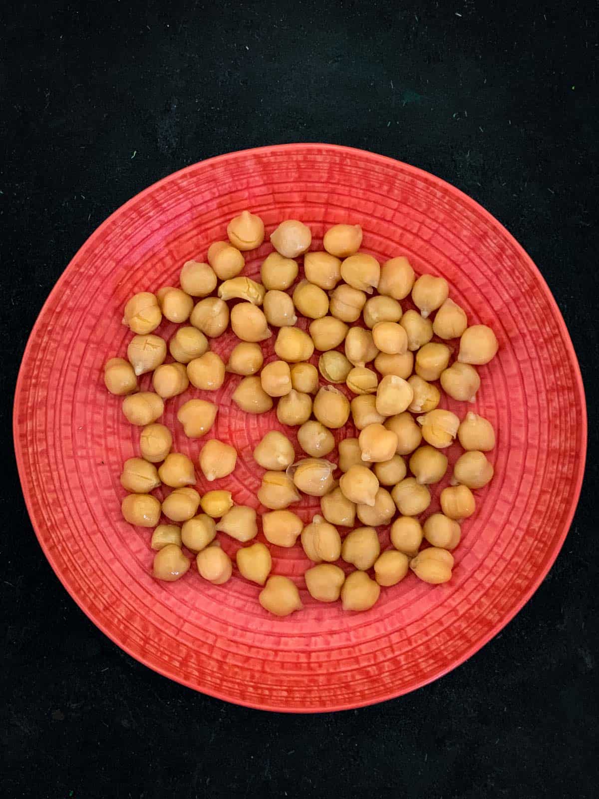 Chickpeas on a tangerine coloured plate