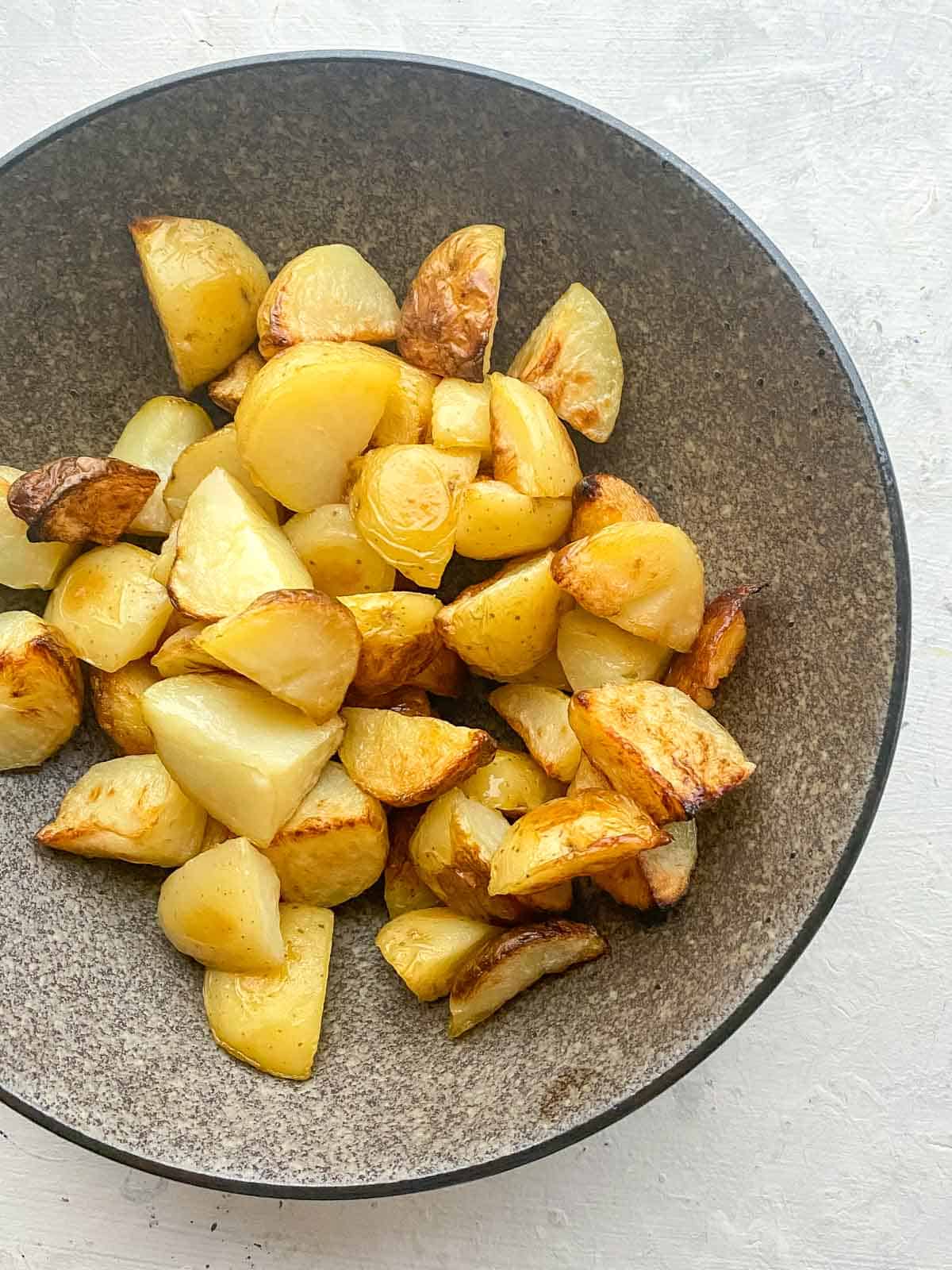 Crispy roast potatoes on a brown bowl