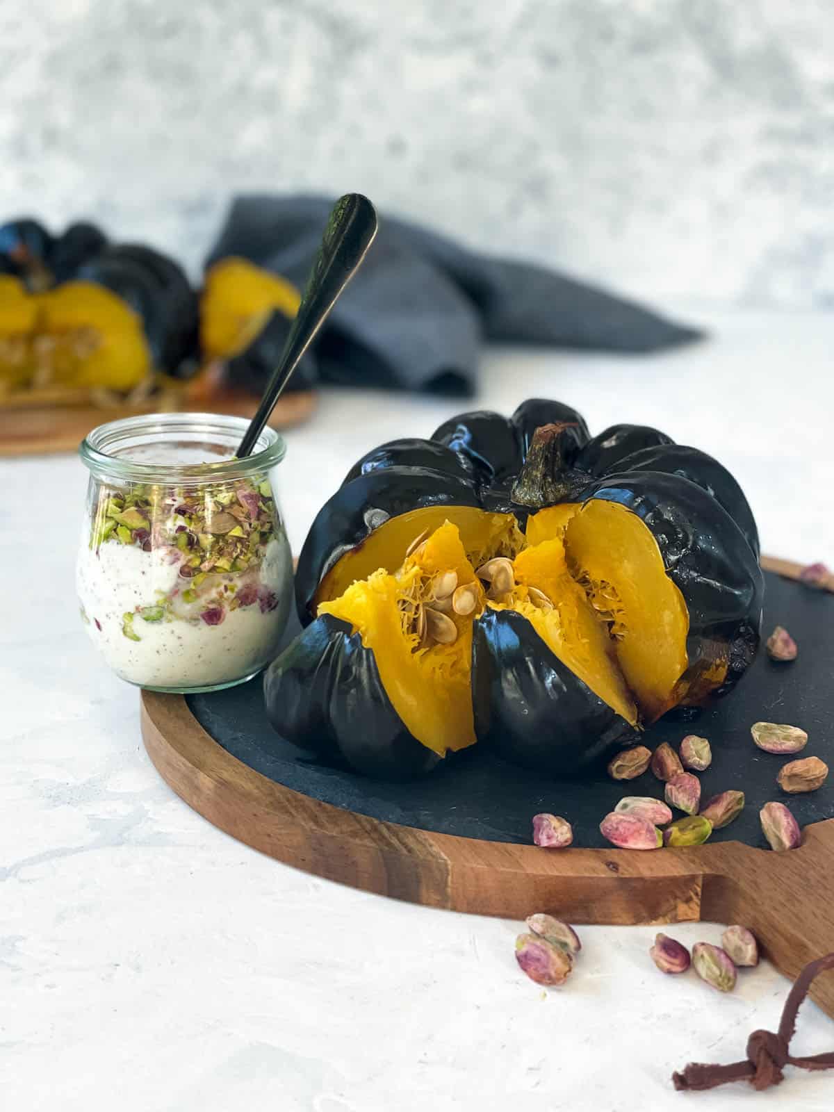 Whole Roasted Heirloom Pumpkin on a wooden board with yoghurt dressing