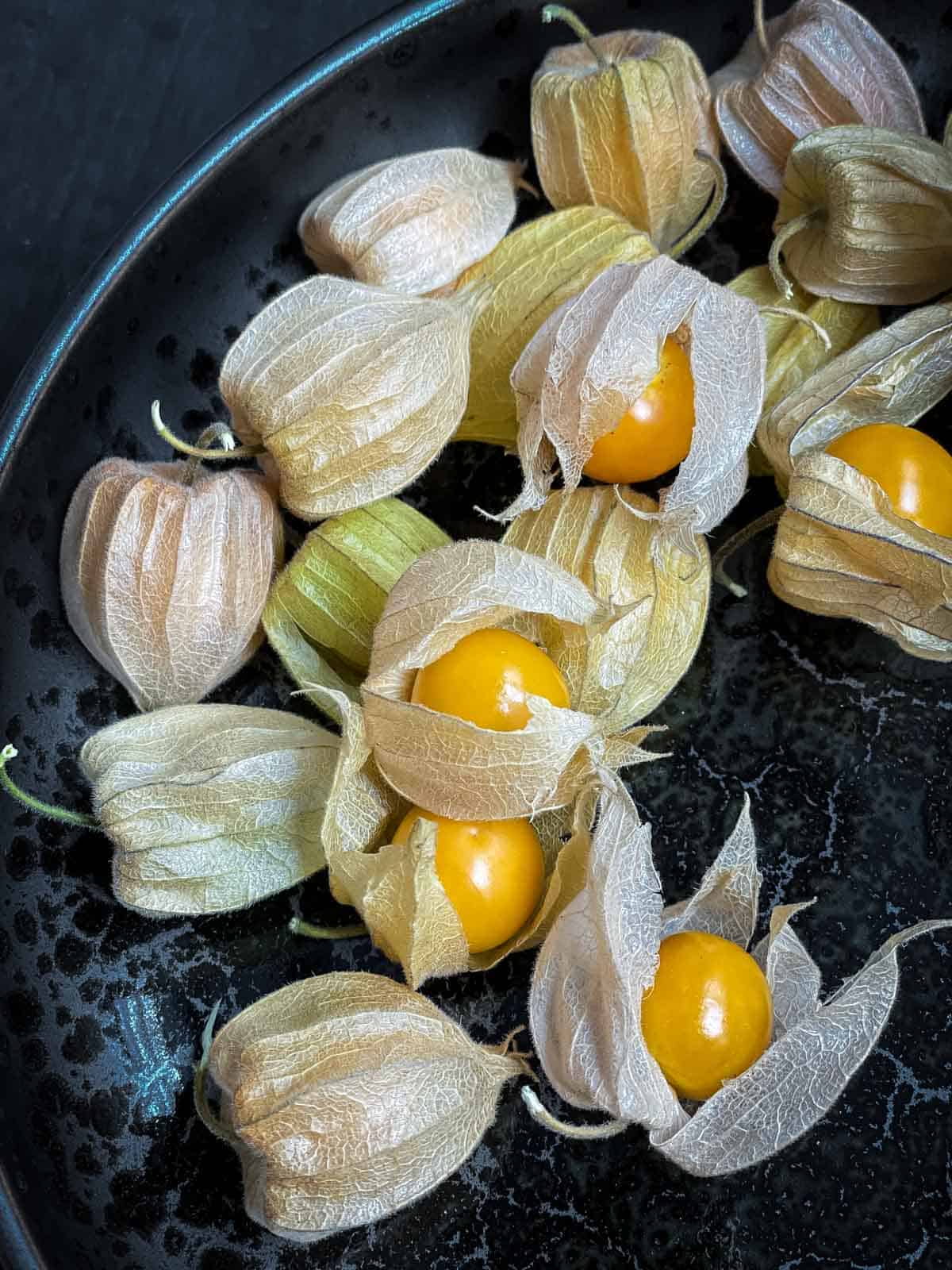 Golden berry or cape gooseberry ono a black and grey plate.