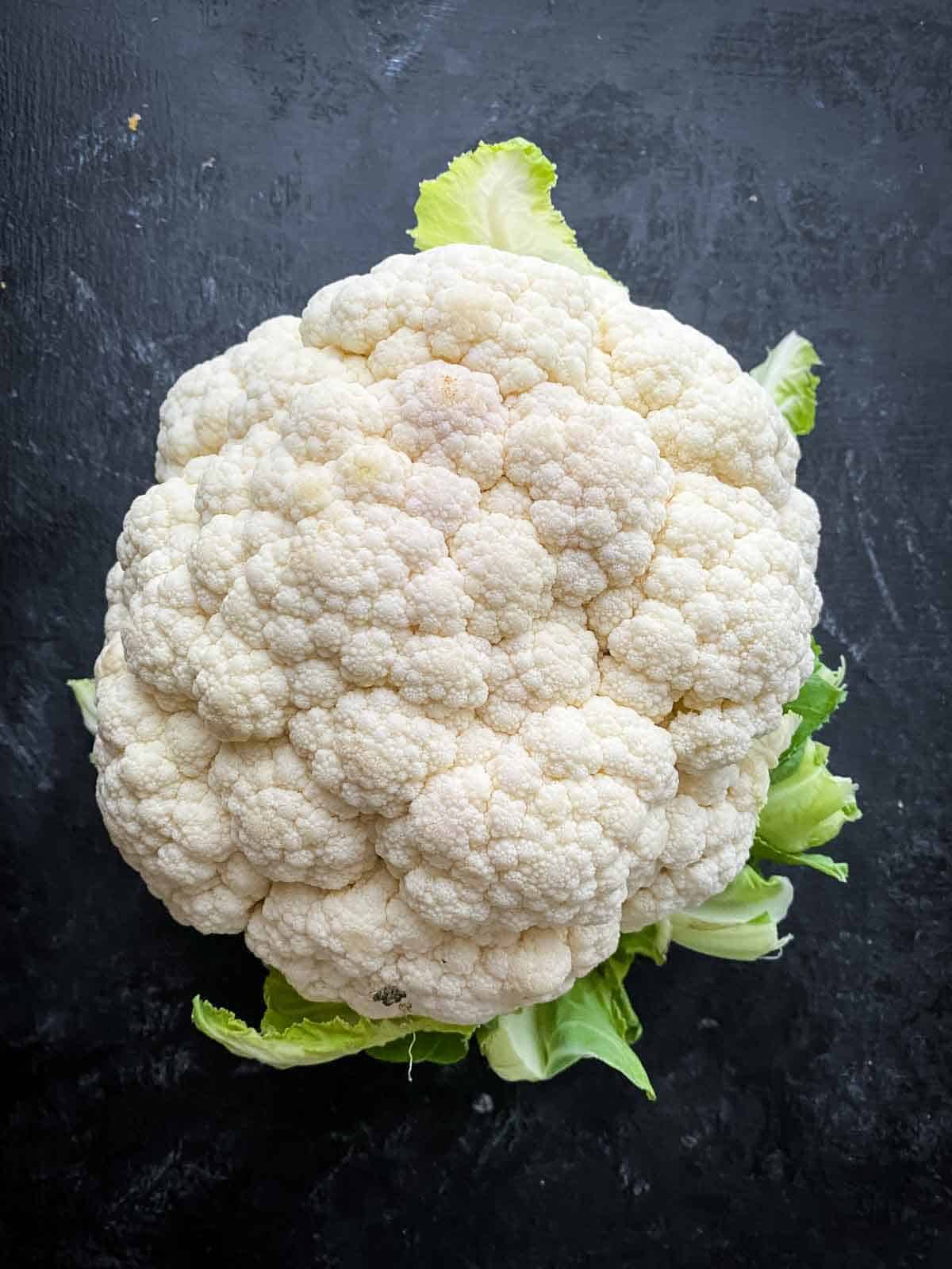 Whole cauliflower with green leaves