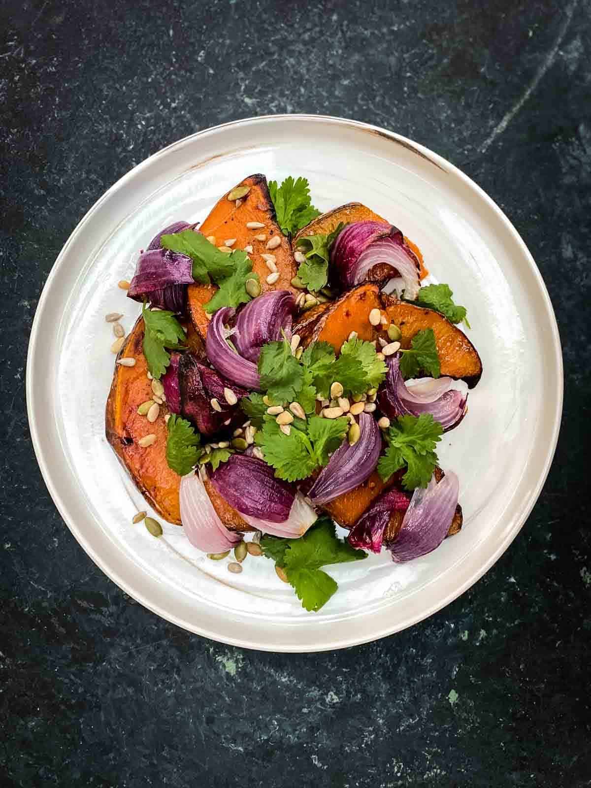 Roasted Spiced Pumpkin Salad on a marbled plate