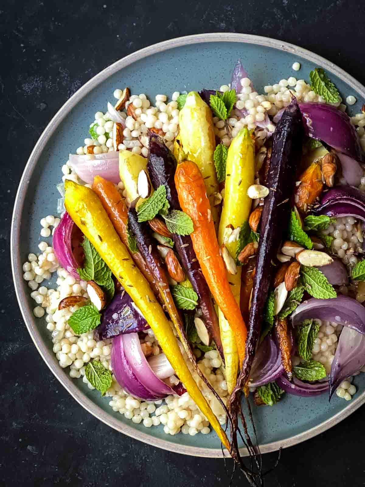 Roasted Rainbow Carrots with Pearl Couscous on a green plate