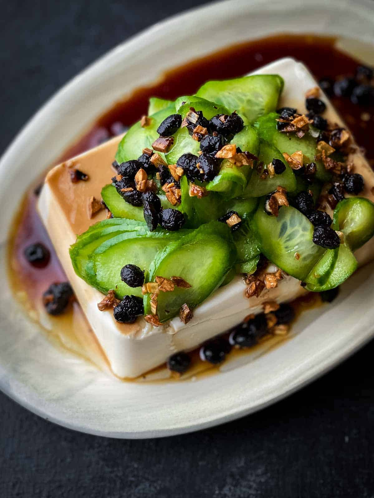 Silken Tofu Recipe with Fried Garlic and Black beans on an oval plate