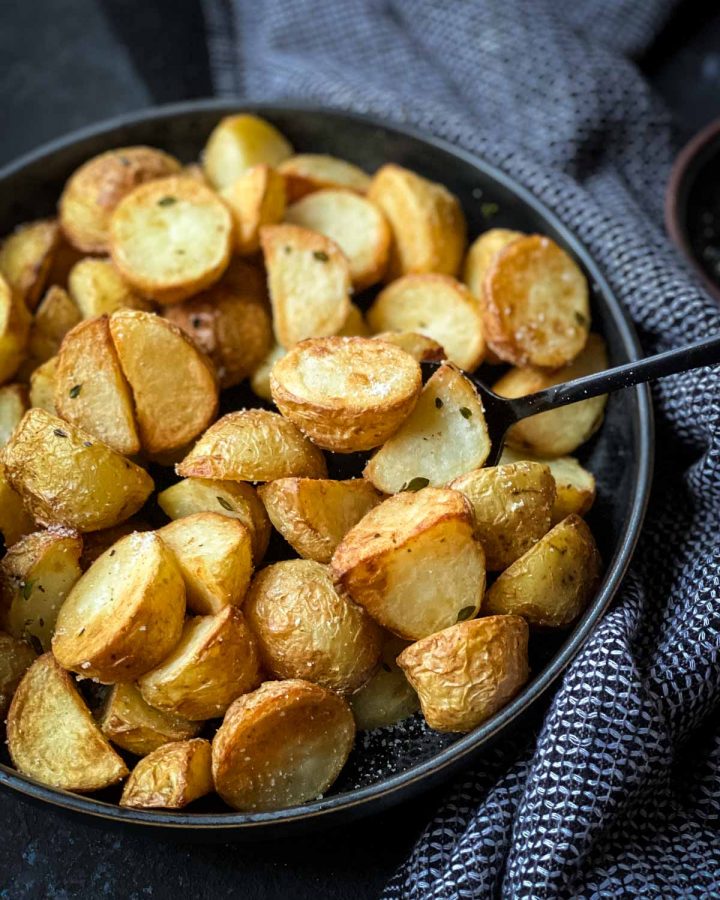 Spoon picking up a serve of Air Fryer Potatoes with Truffle Salt