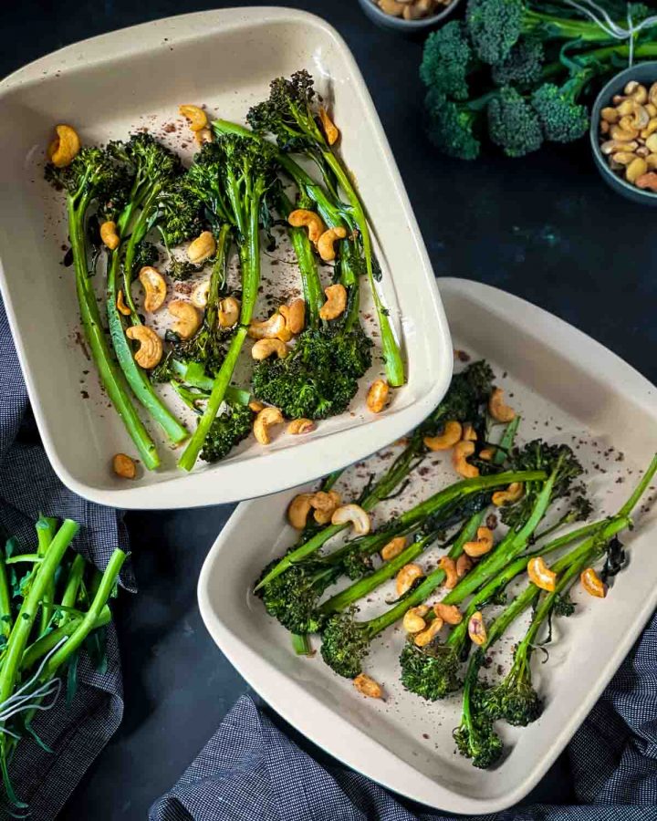 2 baking dishes of Roasted Tenderstem Broccoli and Garlic Cashews with blue napery