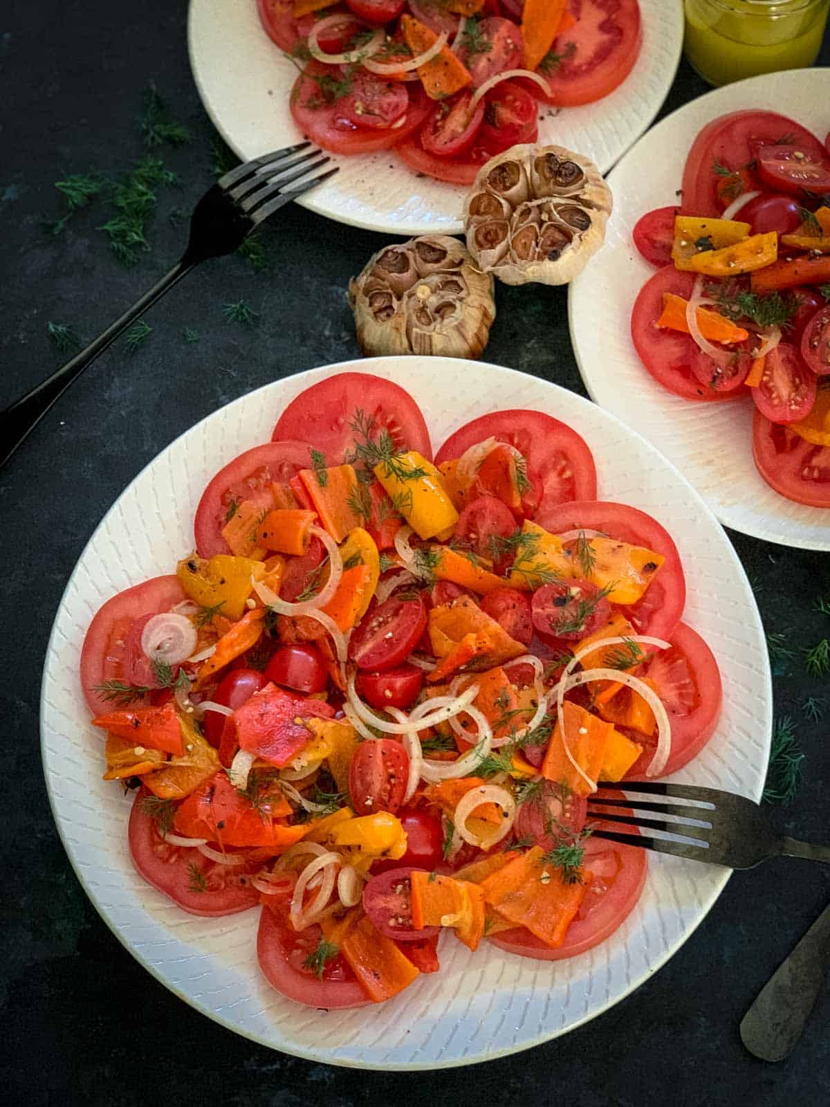3 serves of Baby Bell Peppers Salad with Roasted Garlic on white plates with black forks