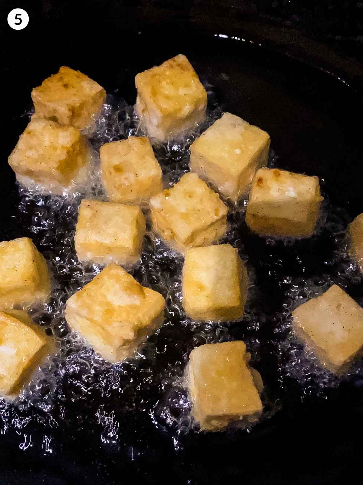 Frying tofu cubes in a fry pan of hot oil