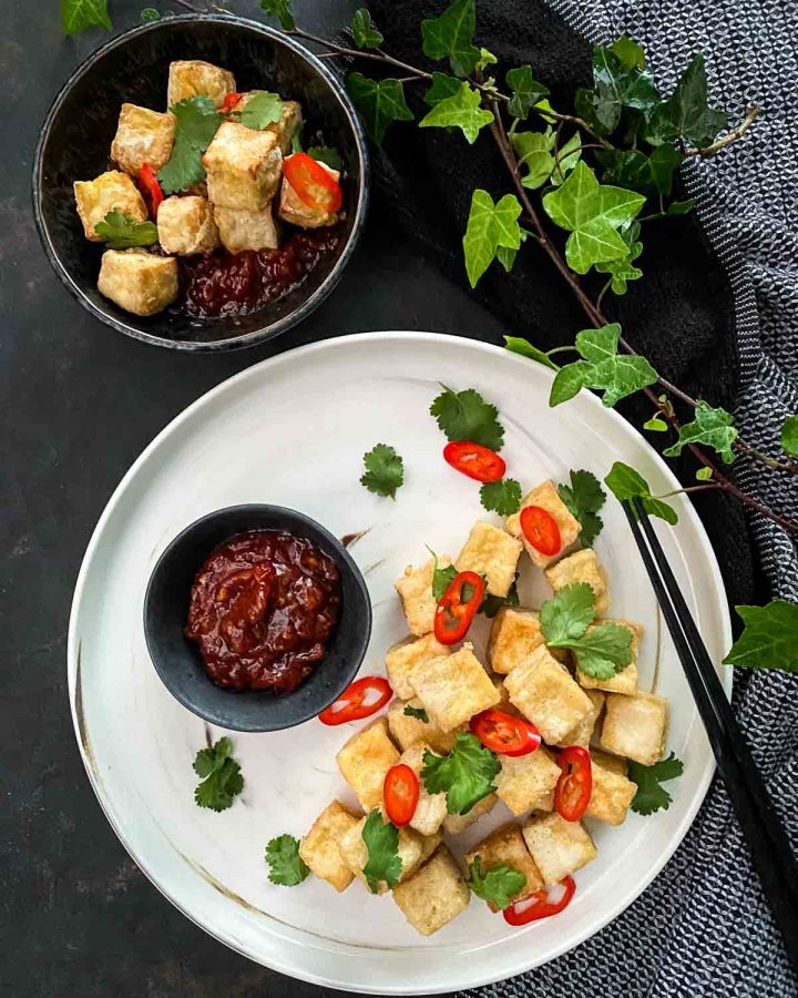 Salt and Pepper Tofu with Sweet Chilli Jam with black chopsticks and blue napery