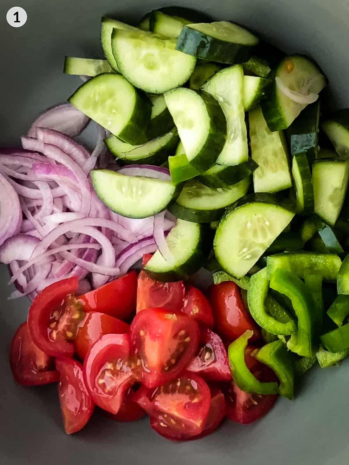 Cut red onion, cucu,ber, green peppers and cherry tomatoes in a bowl