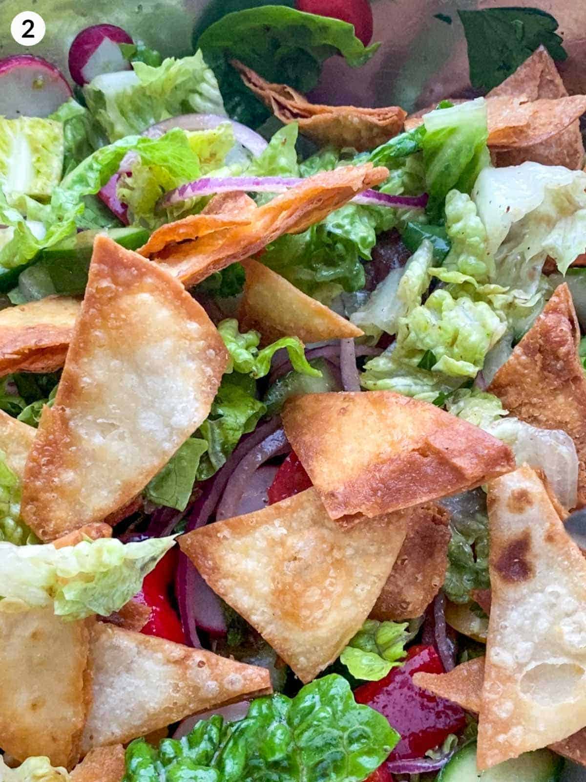Mixing the ingredients of a Fattoush Salad with fried flat bread
