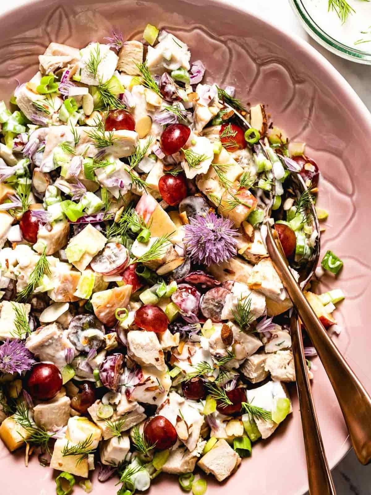 Greek yoghurt chicken salad served on a pink salad platter and rose gold coloured cutlery