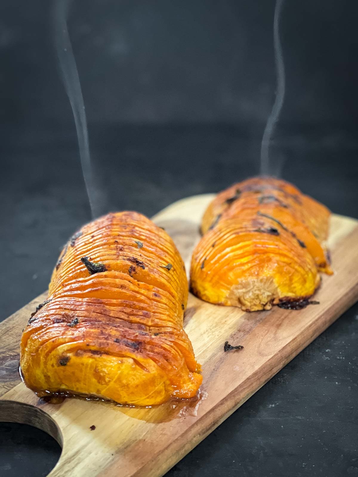 Steam hot roasted butternut squash on a wooden chopping board