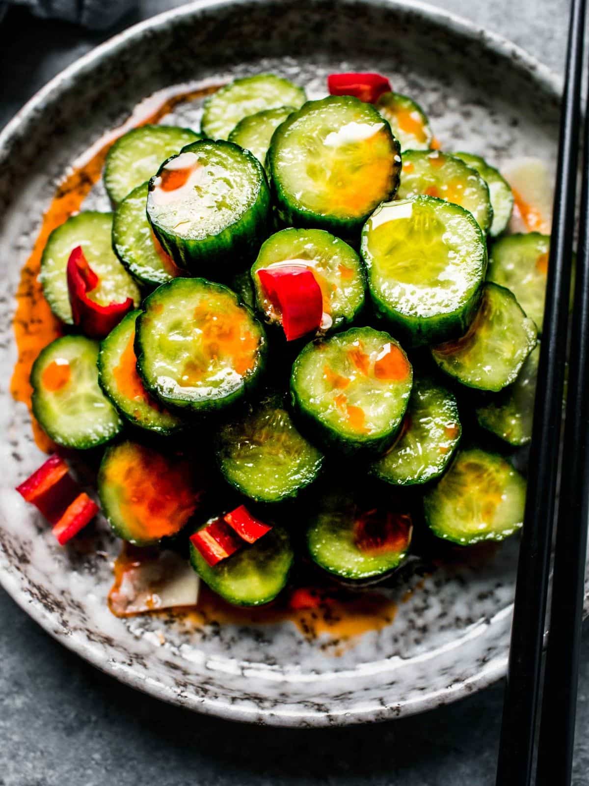 Din Tai fung copy cat cucumber salad in a marbled bowl with a set of black chopsticks
