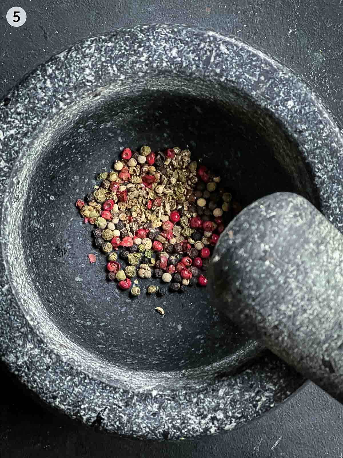 Rainbow peppercorns in a mortar and pestle