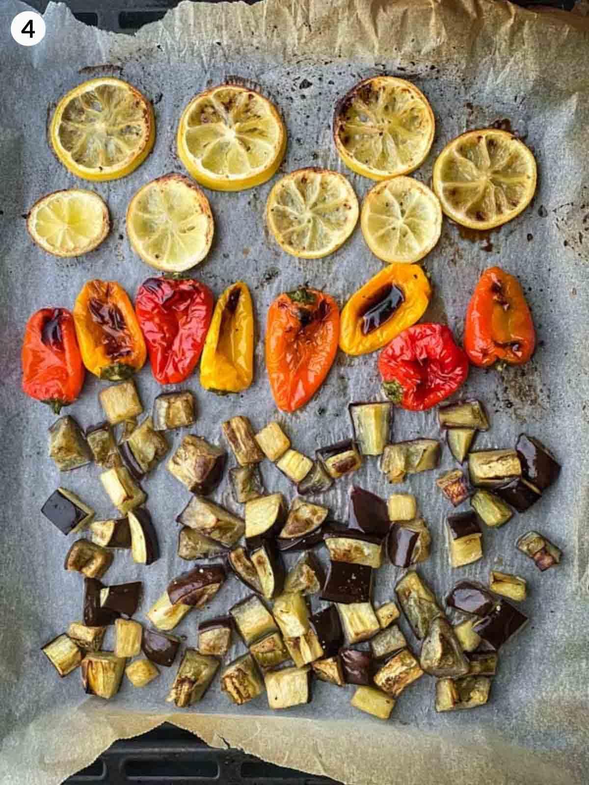roasted lemon, bell peppers and eggplant on a lined baking tray