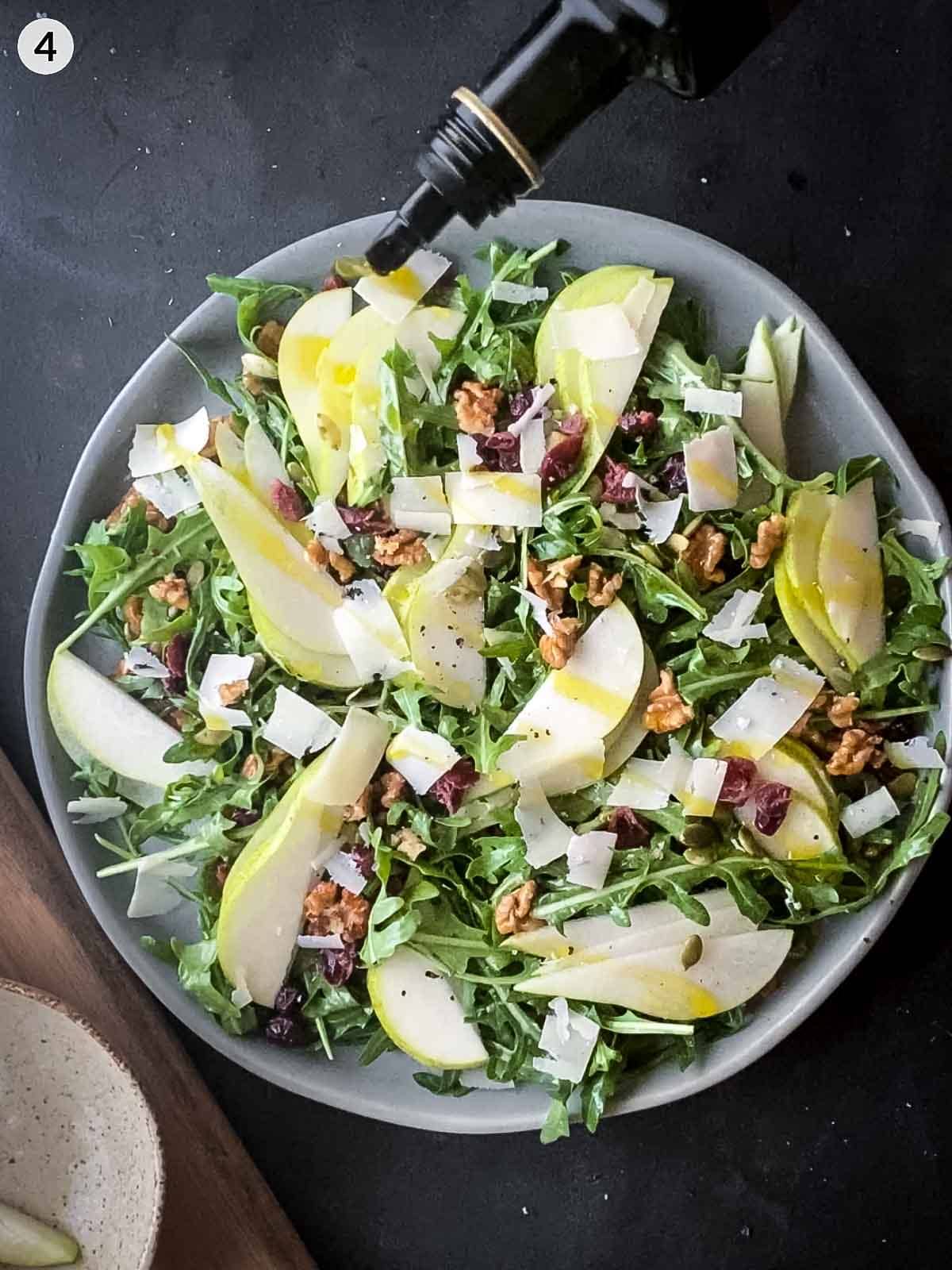 drizzling extra virgin olive oil over salad
