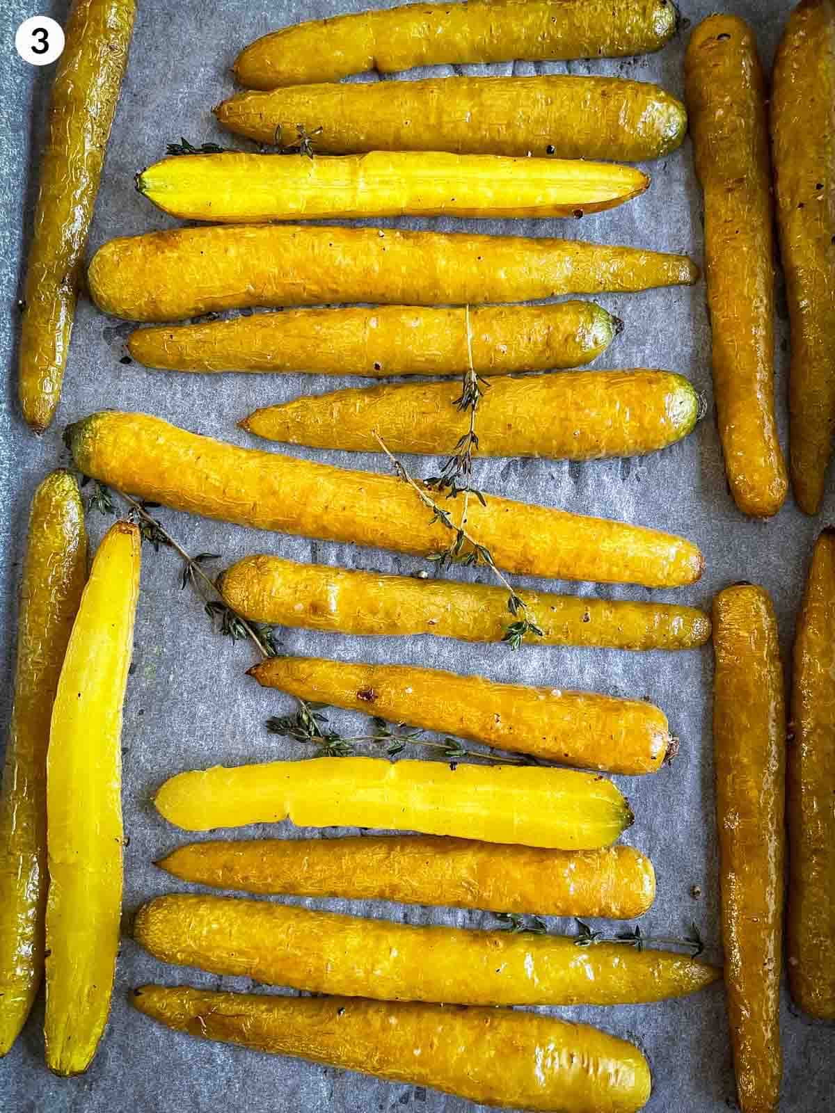 Rosted yellow carrots in parchment lined sheet pan