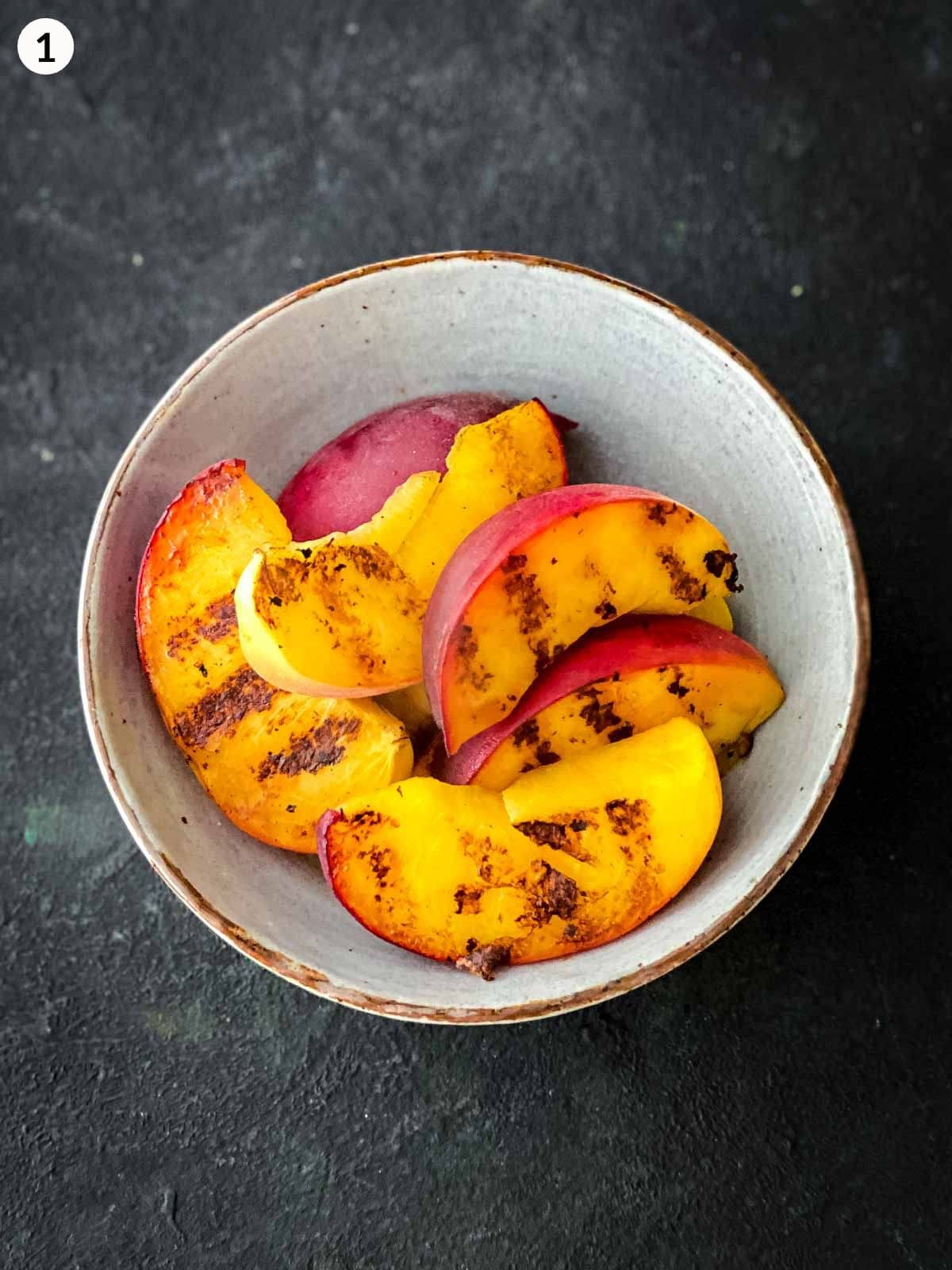 wedges of grilled peaches in a bowl