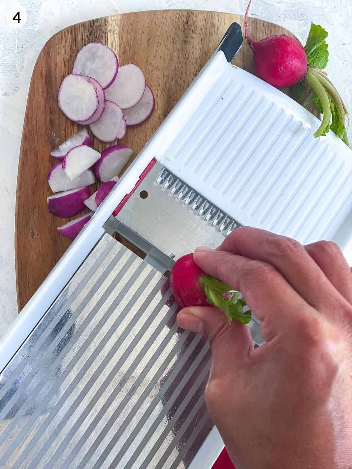 using a mandolin to slice radishes on a wooden board