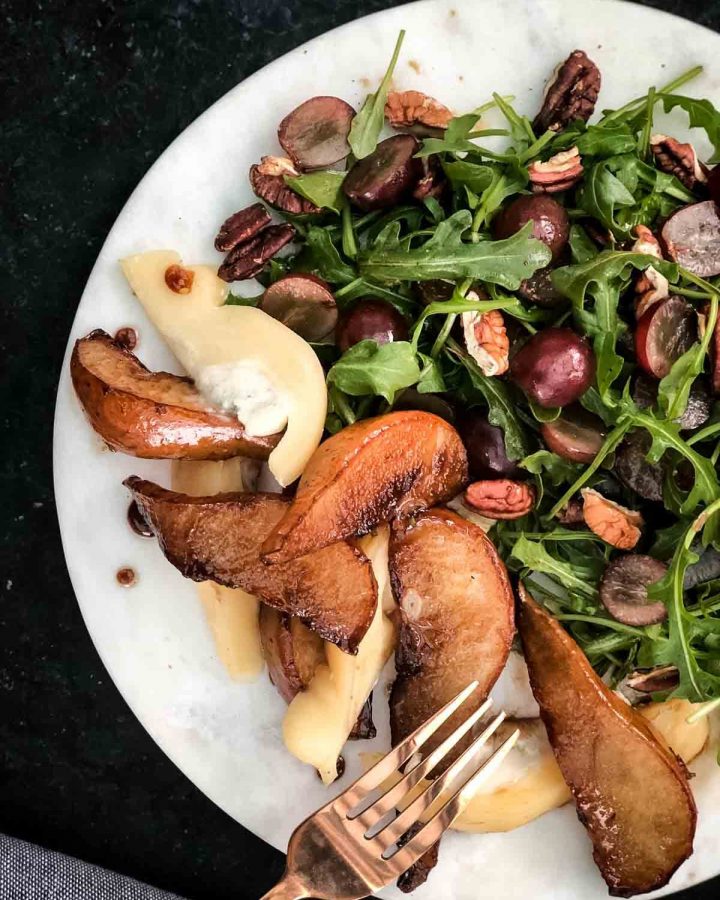 Pear and Rocket Salad with Provoleta Blue Cheese in a white plate with a rose gold fork