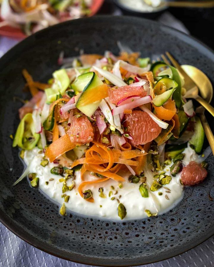 Salad with Courgette, Carrot and Fennel on a dark plate with gold cutlery