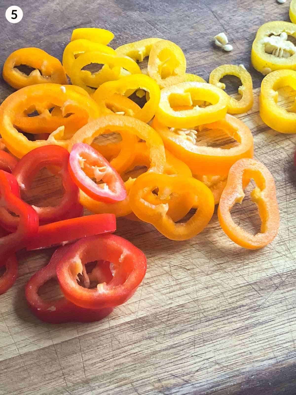 sliced baby peppers on wooden chopping board