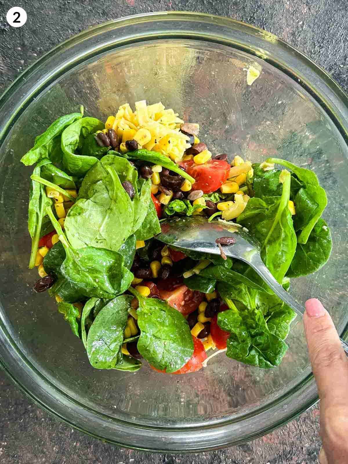 Mixing Santa Fe salad ingredients in a glass bowl with a spoon
