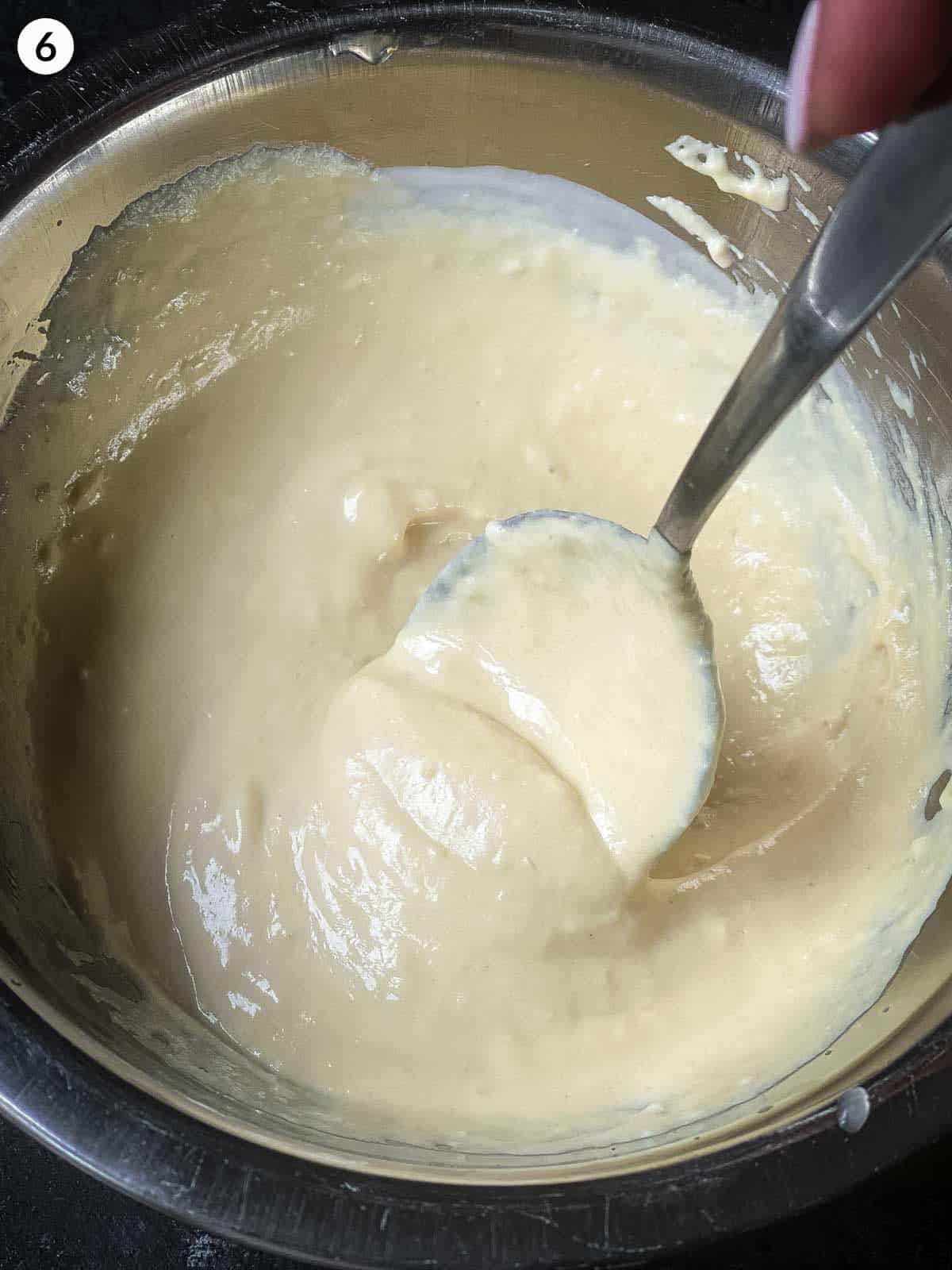 mixing hummus dressing together with spoon