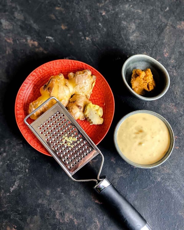 Miso Mayo Dressing in a small bowl with ginger and a grater and miso next to it