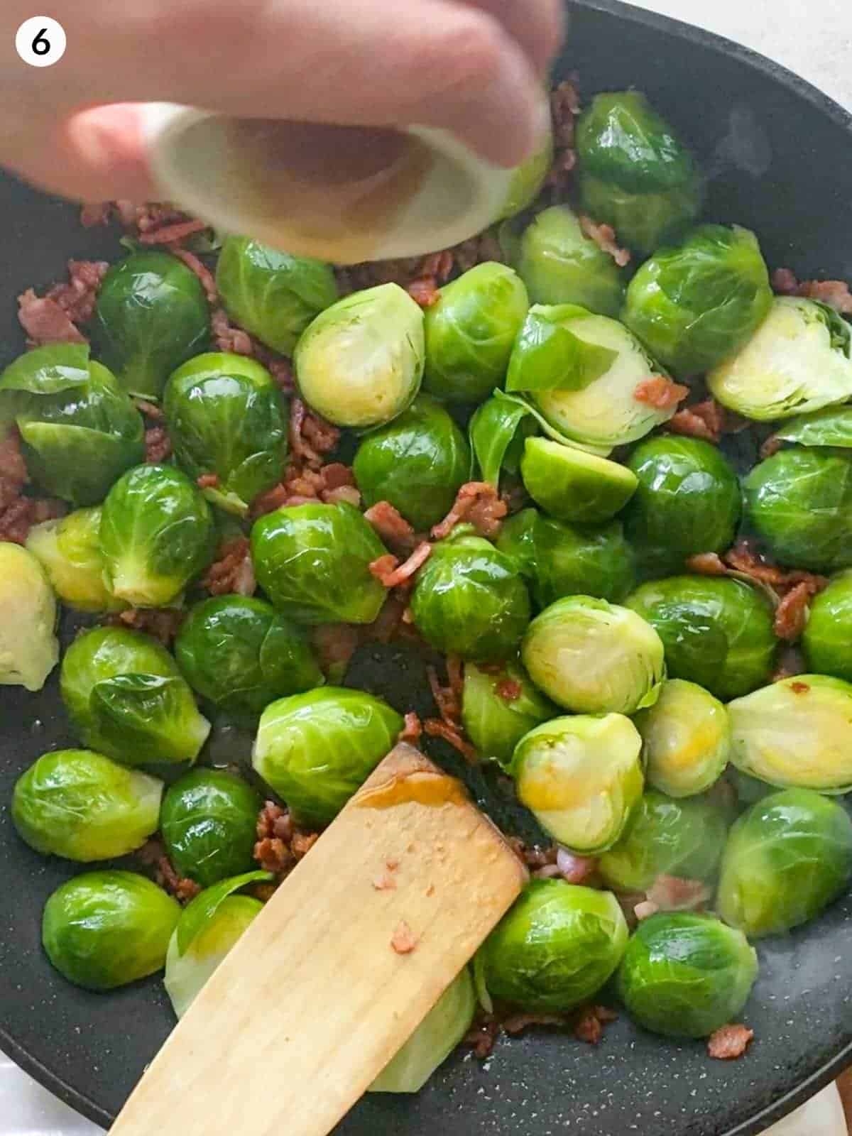 Adding maple syrup to Brussels Sprouts With Bacon in a fry pan